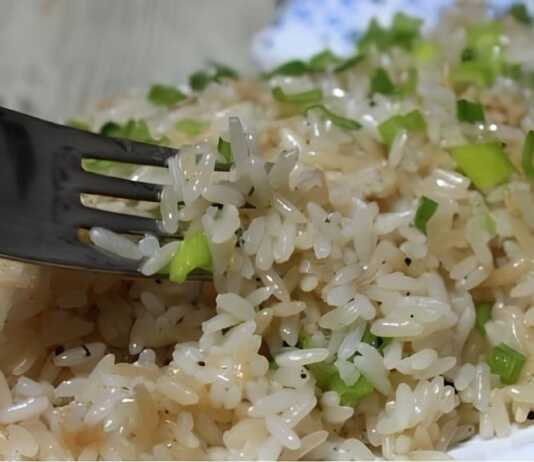 Ένα πιάτο με λαχταριστό, σπυρωτό ρύζι αρωματισμένο με βότανα, όπου κάθε κόκκος φαίνεται ξεχωριστός και καλομαγειρεμένος.