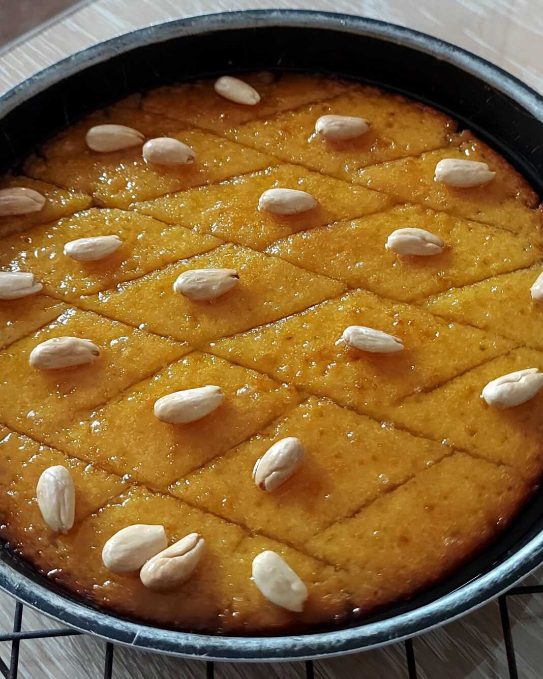 Παραδοσιακό χρυσαφένιο σάμαλι κομμένο σε ρόμβους με ένα λευκό αμύγδαλο στην κορυφή, καλά σιροπιασμένο.