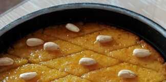 Παραδοσιακό χρυσαφένιο σάμαλι κομμένο σε ρόμβους με ένα λευκό αμύγδαλο στην κορυφή, καλά σιροπιασμένο.