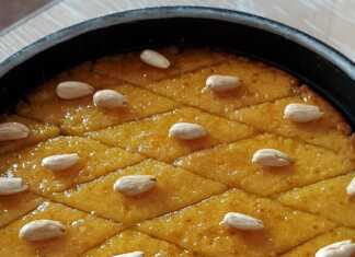 Παραδοσιακό χρυσαφένιο σάμαλι κομμένο σε ρόμβους με ένα λευκό αμύγδαλο στην κορυφή, καλά σιροπιασμένο.