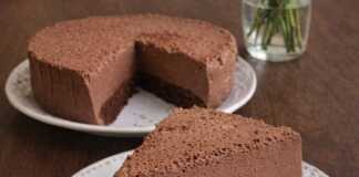 Ένα λαχταριστό κομμάτι σοκολατένιο cheesecake με λεία υφή και σκούρο κακάο, σερβιρισμένο σε λευκό πιάτο.