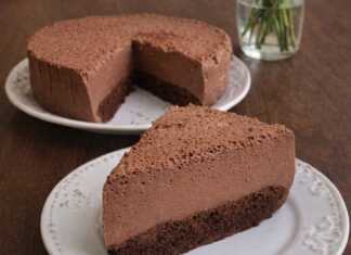 Ένα λαχταριστό κομμάτι σοκολατένιο cheesecake με λεία υφή και σκούρο κακάο, σερβιρισμένο σε λευκό πιάτο.