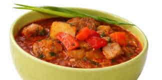 Αχνιστή σούπα γκούλας σε πήλινο μπολ με μεγάλα κομμάτια κρέατος πατάτες και κατακόκκινη σάλτσα παπρίκας