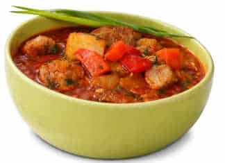 Αχνιστή σούπα γκούλας σε πήλινο μπολ με μεγάλα κομμάτια κρέατος πατάτες και κατακόκκινη σάλτσα παπρίκας