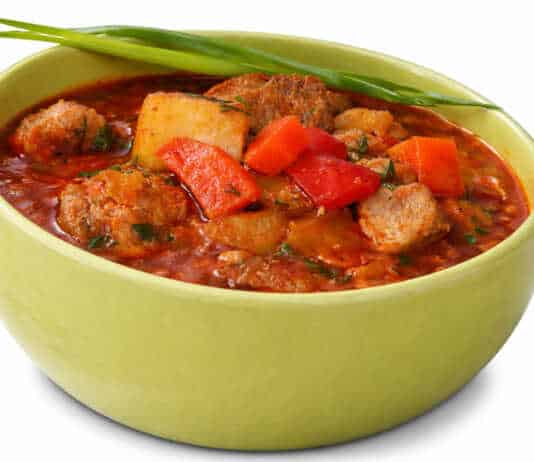 Αχνιστή σούπα γκούλας σε πήλινο μπολ με μεγάλα κομμάτια κρέατος πατάτες και κατακόκκινη σάλτσα παπρίκας