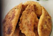 Χρυσαφένια τηγανιτά πιτάκια μέσα σε ένα πιάτο, με λιωμένο τυρί και κομμάτια μπέικον να φαίνονται στο εσωτερικό τους.