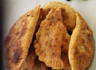 Χρυσαφένια τηγανιτά πιτάκια μέσα σε ένα πιάτο, με λιωμένο τυρί και κομμάτια μπέικον να φαίνονται στο εσωτερικό τους.