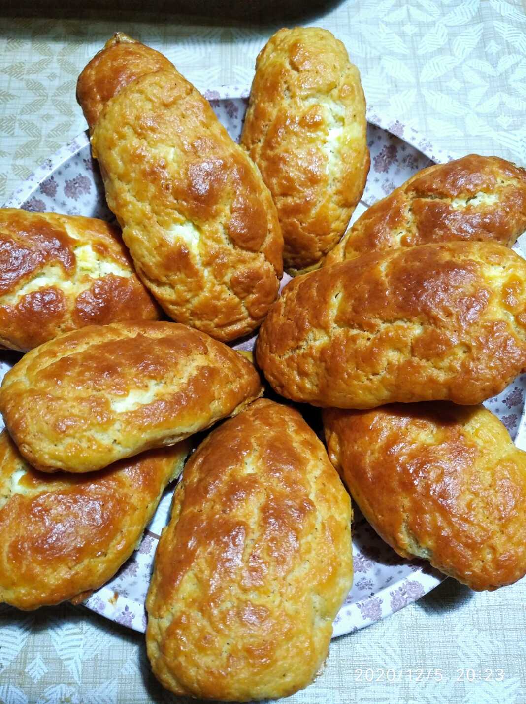 Λαχταριστές, χρυσαφένιες τυρόπιτες κουρού τοποθετημένες σε σειρά πάνω σε μια πιατέλα, πασπαλισμένες προαιρετικά με σουσάμι.