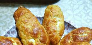 Λαχταριστές, χρυσαφένιες τυρόπιτες κουρού τοποθετημένες σε σειρά πάνω σε μια πιατέλα, πασπαλισμένες προαιρετικά με σουσάμι.