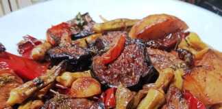 Ένα ταψί με παραδοσιακό τουρλού λαχανικών, με μελιτζάνες, πιπεριές και μπάμιες σε πλούσια κόκκινη σάλτσα, γαρνιρισμένο με φρέσκο μαϊντανό.