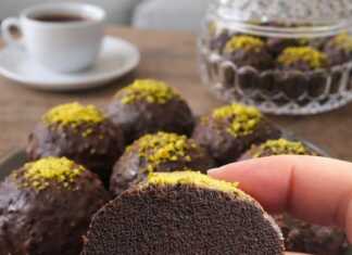 Στρογγυλά σοκολατένια τρουφάκια καλυμμένα με γυαλιστερό γλάσο σοκολάτας, τοποθετημένα επάνω σε λαδόκολλα.