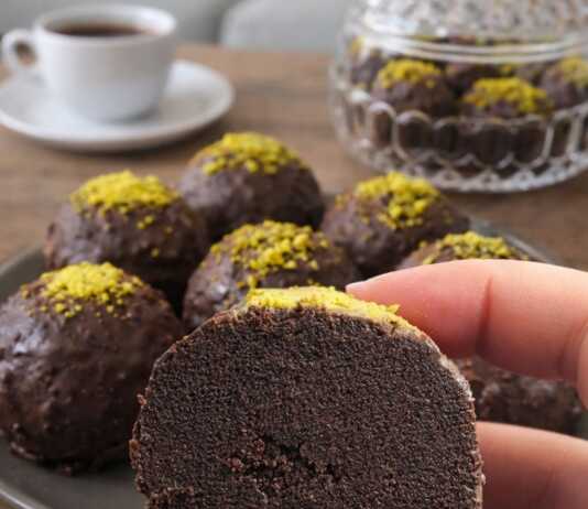 Στρογγυλά σοκολατένια τρουφάκια καλυμμένα με γυαλιστερό γλάσο σοκολάτας, τοποθετημένα επάνω σε λαδόκολλα.