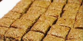 Ένας χειροποίητος χαλβάς από ηλιόσπορους και μέλι, κομμένος σε ομοιόμορφα τετράγωνα κομμάτια, τοποθετημένος σε ξύλινη επιφάνεια.