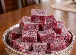 Μικροί κύβοι από χειροποίητα ζελεδάκια βατόμουρου σε έντονο κόκκινο χρώμα, καλυμμένοι με ζάχαρη και τοποθετημένοι σε σειρά.