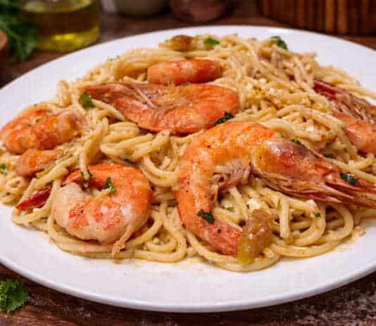 Ζουμερή γαριδομακαρονάδα με πλούσια σάλτσα μουστάρδας, γαρνιρισμένη με φρέσκο μαϊντανό και τριμμένη φέτα