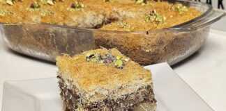 Ένα ταψί με χρυσαφένιο, σιροπιασμένο κανταΐφι κομμένο σε κομμάτια, πασπαλισμένο με καταπράσινο τριμμένο φυστίκι Αιγίνης