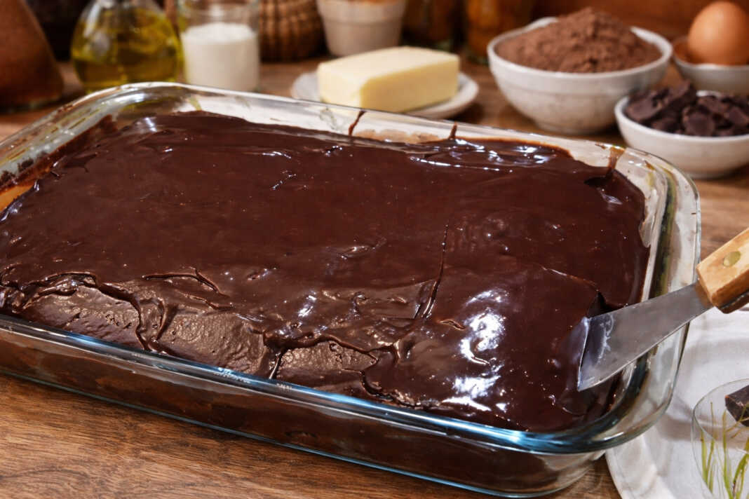 Αφράτο κέικ σοκολάτας καλυμμένο με γυαλιστερό ζεστό γλάσο, κομμένο σε τετράγωνα κομμάτια