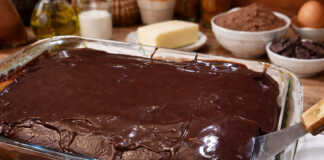 Αφράτο κέικ σοκολάτας καλυμμένο με γυαλιστερό ζεστό γλάσο, κομμένο σε τετράγωνα κομμάτια