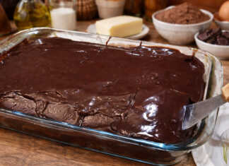 Αφράτο κέικ σοκολάτας καλυμμένο με γυαλιστερό ζεστό γλάσο, κομμένο σε τετράγωνα κομμάτια