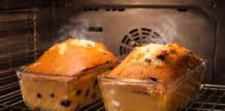 Δύο μεγάλα αχνιστά κέικ με σταφίδες, ροδισμένα στην επιφάνεια και πασπαλισμένα με λίγη ζάχαρη άχνη