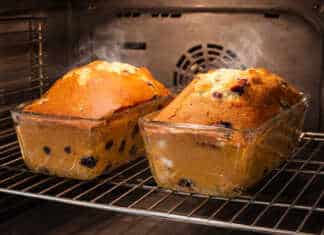 Δύο μεγάλα αχνιστά κέικ με σταφίδες, ροδισμένα στην επιφάνεια και πασπαλισμένα με λίγη ζάχαρη άχνη