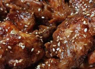 καραμελωμένες φτερούγες κοτόπουλου σε σκούρα σάλτσα βαλσάμικου, πασπαλισμένες με μπόλικο καβουρδισμένο σουσάμι