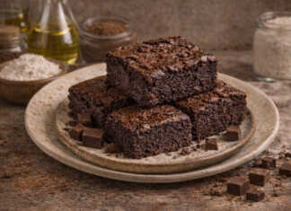 Λαχταριστά κομμάτια από Νηστίσιμο σοκολατένιο μπράουνι με υγρό κέντρο, τοποθετημένα το ένα πάνω στο άλλο σε ξύλινη επιφάνεια