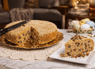 Αφράτη Σταφιδόπιτα με άρωμα τσουρεκιού, πασπαλισμένη με σουσάμι και κομμένη σε ρόμβους πάνω σε ξύλινη επιφάνεια