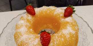 Ένα δροσερό πορτοκαλί γλυκό ψυγείου ξεφορμαρισμένο από φόρμα σιλικόνης πασπαλισμένο με λευκό ινδοκάρυδο στην κορυφή