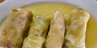 Καλοτυλιγμένοι νηστίσιμοι λαχανοντολμάδες μέσα στην κατσαρόλα, περιχυμένοι με λευκή σάλτσα και πασπαλισμένοι με φρέσκα μυρωδικά