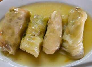 Καλοτυλιγμένοι νηστίσιμοι λαχανοντολμάδες μέσα στην κατσαρόλα, περιχυμένοι με λευκή σάλτσα και πασπαλισμένοι με φρέσκα μυρωδικά