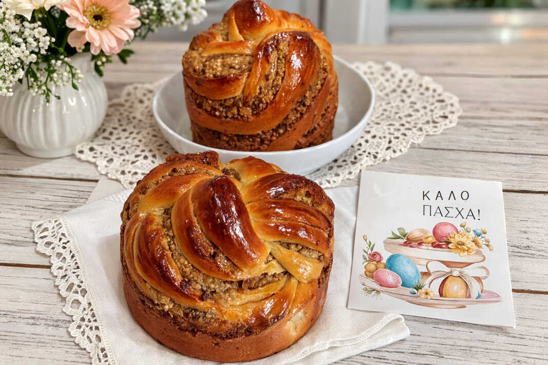 Δύο περίτεχνα πλεγμένα γεμιστά πασχαλινά τσουρέκια με σιρόπι, με χρυσαφένια κρούστα και ορατή τη γέμιση καρυδιού
