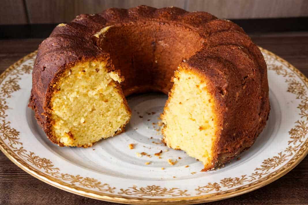 Εντυπωσιακό κέικ Bundt πορτοκαλιού πασπαλισμένο με πάνω σε piatela