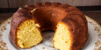 Εντυπωσιακό κέικ Bundt πορτοκαλιού πασπαλισμένο με πάνω σε piatela