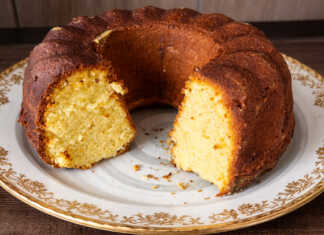 Εντυπωσιακό κέικ Bundt πορτοκαλιού πασπαλισμένο με πάνω σε piatela