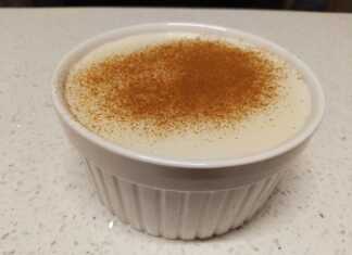 Ένα λευκό μπολ με κρεμώδες ρυζόγαλο πασπαλισμένο με μπόλικη κανέλα στην κορυφή