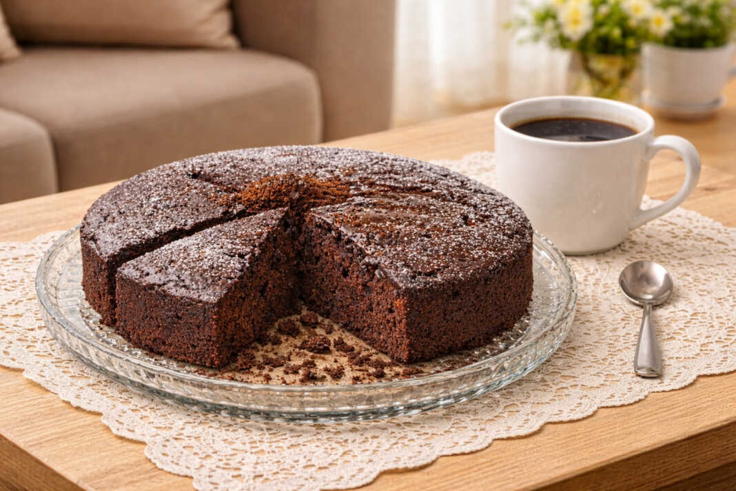 Ένα φουσκωτό και σκούρο σοκολατένιο κέικ κομμένο σε κομμάτια πάνω σε μια ξύλινη επιφάνεια