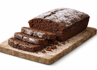 Λαχταριστό νηστίσιμο σοκολατένιο κέικ πασπαλισμένο με άχνη ζάχαρη σε πιατέλα