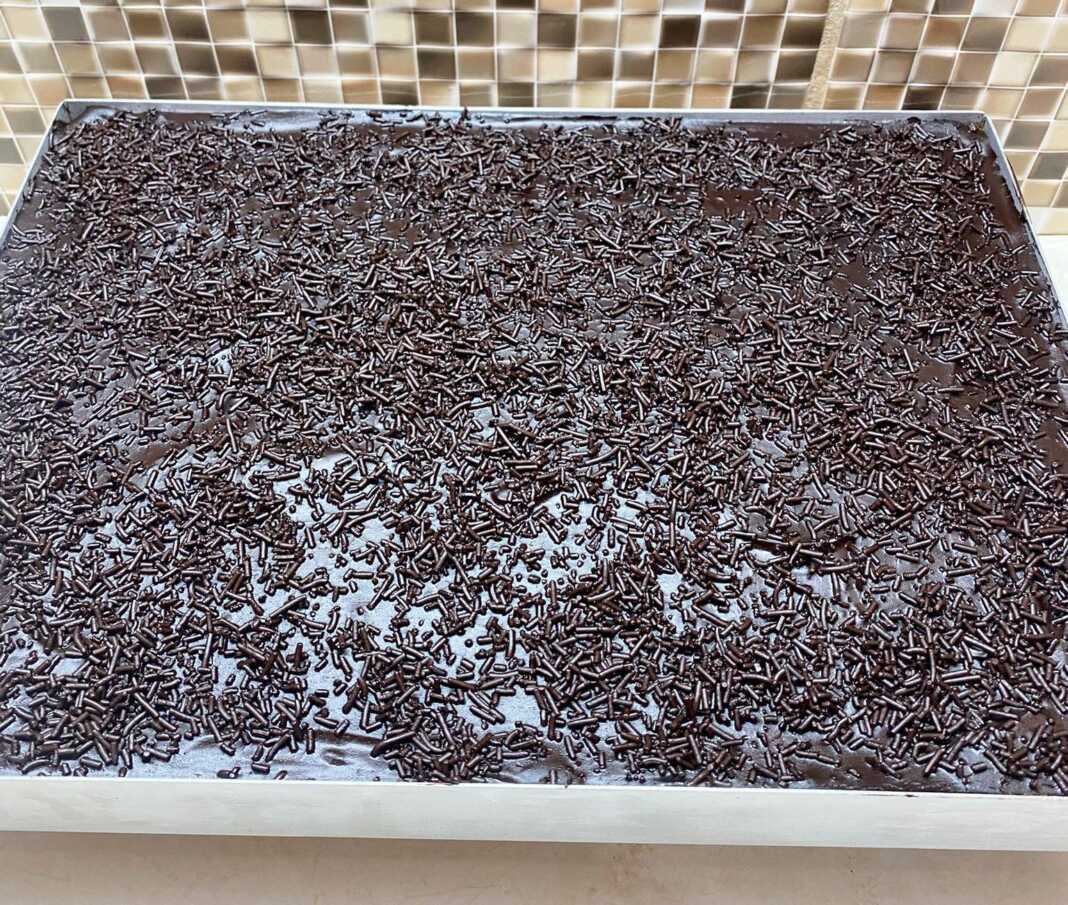 Λαχταριστή Σοκολατόπιτα νηστίσιμη με παχύρρευστο γλάσο σοκολάτας και πασπαλισμένη με μαύρη τρούφα κουβερτούρας, κομμένη σε τετράγωνα κομμάτια