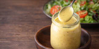 Κρεμώδης σάλτσα honey mustard σε μικρό μπολ δίπλα σε τραγανή σαλατα