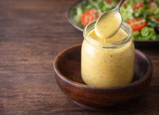 Κρεμώδης σάλτσα honey mustard σε μικρό μπολ δίπλα σε τραγανή σαλατα