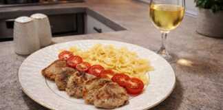 Ζουμερά μενταγιόν από χοιρινό φιλέτο σερβιρισμένα με ζυμαρικά φαρφάλε και φρέσκα κομμένα ντοματίνια σε λευκό πιάτο