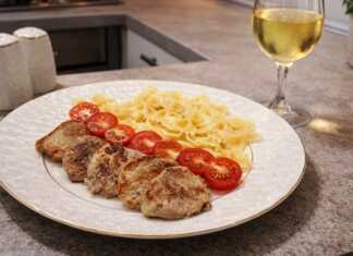 Ζουμερά μενταγιόν από χοιρινό φιλέτο σερβιρισμένα με ζυμαρικά φαρφάλε και φρέσκα κομμένα ντοματίνια σε λευκό πιάτο