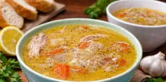 Μπολ με αχνιστή κοτόσουπα αυγολέμονο, κομμάτια από τρυφερό κοτόπουλο, καρότα και κριθαράκι, γαρνιρισμένο με φρεσκοτριμμένο πιπέρι