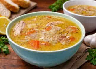 Μπολ με αχνιστή κοτόσουπα αυγολέμονο, κομμάτια από τρυφερό κοτόπουλο, καρότα και κριθαράκι, γαρνιρισμένο με φρεσκοτριμμένο πιπέρι