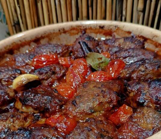 Ταψάκι με ροδοκοκκινισμένα κεφτεδάκια, φρέσκα ψημένα ντοματίνια και πλούσια κόκκινη σάλτσα.