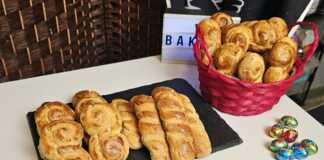 Παραδοσιακά πασχαλινά κουλουράκια αμμωνίας με μαστίχα και μαχλέπι Σειρές από χρυσαφένια πλεγμένα πασχαλινά κουλουράκια αμμωνίας πάνω σε λαδόκολλα, γυαλιστερά από το άλειμμα αυγού