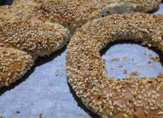 Φρεσκοψημένα κουλούρια Θεσσαλονίκης γεμάτα σουσάμι πάνω σε αντικολλητικό χαρτί, με χρυσαφένια όψη και παραδοσιακό σχήμα κρίκου και κοτσιδα