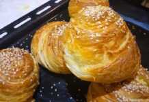 Μια πιατέλα με χρυσαφένια, στρογγυλά κρεατοπιτάκια, με ορατές τις λεπτές στρώσεις της ζύμης που θυμίζουν σφολιάτα, πασπαλισμένα με σουσάμι.