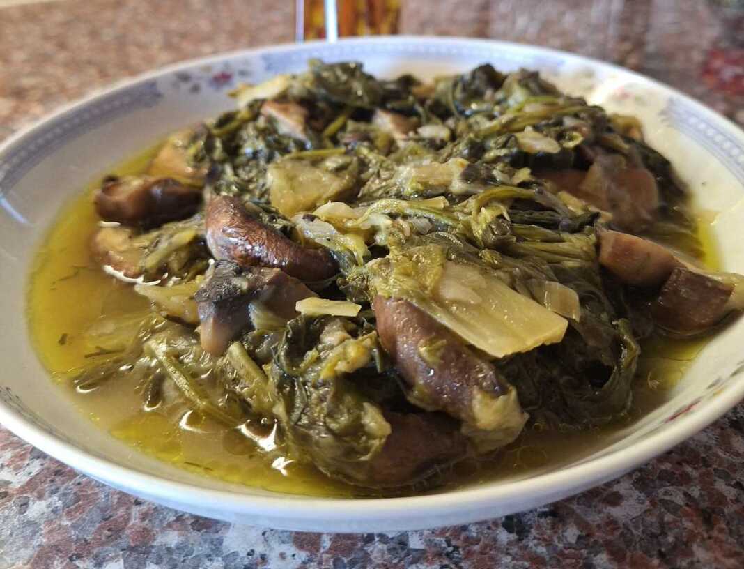 Ενα πιάτο με ζουμερά μανιτάρια φρικασέ, πράσινα λαχανικά και πλούσια λεμονάτη σάλτσα.